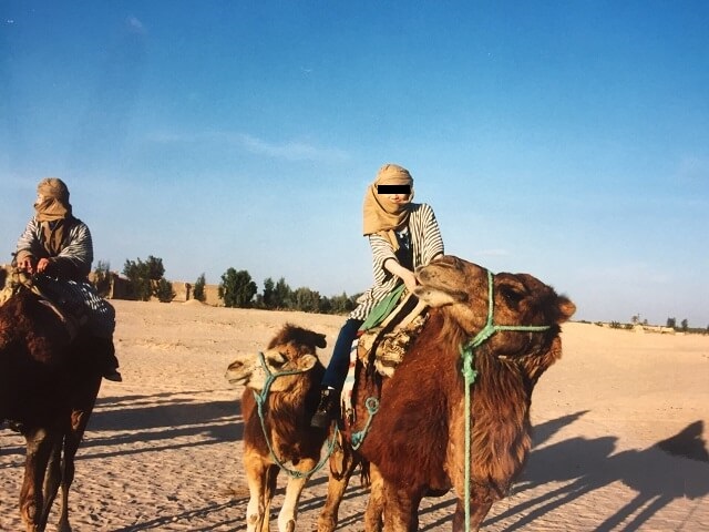 チュニジアのサハラ砂漠でラクダに乗る